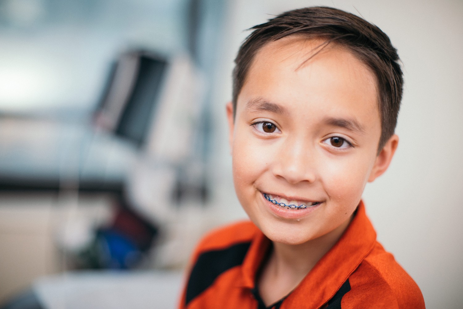 A smiling boy with braces in the exam room.