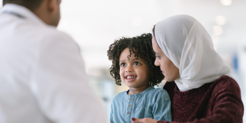 Daughter sits with mother while consulting physician.