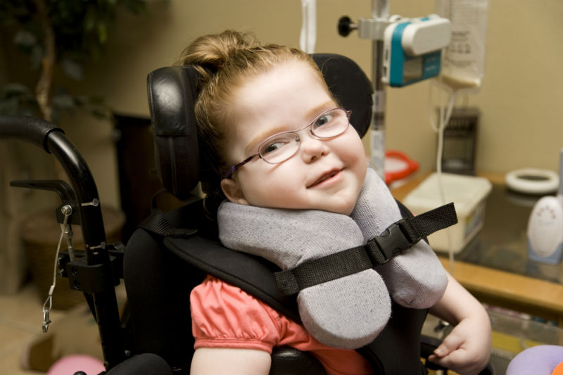 Little Girl with Cerebral Palsy sitting in her wheel chair.