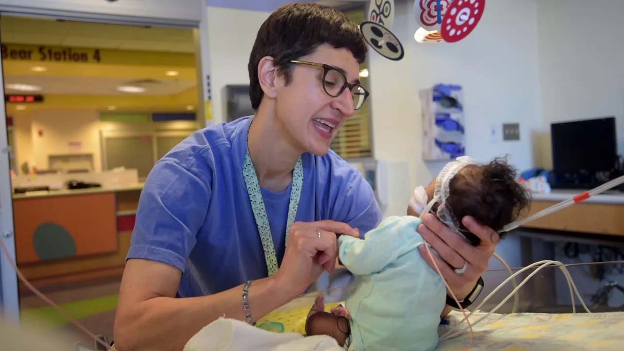 Doctor holding infant in CICU
